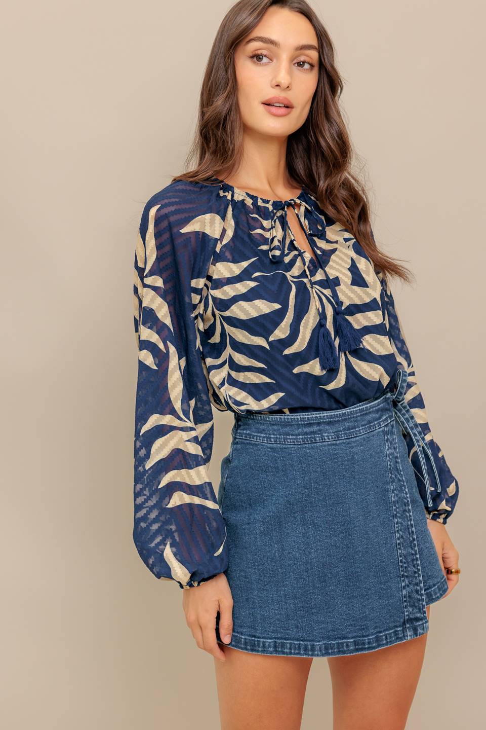 Woman wearing a long sleeve navy blue and beige leaf patterned blouse | Flying Tomato