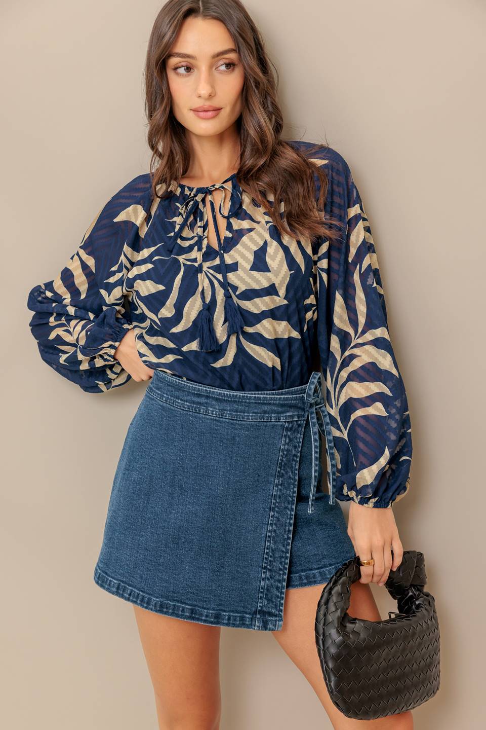 Woman wearing a long sleeve navy blue and beige leaf patterned blouse | Flying Tomato