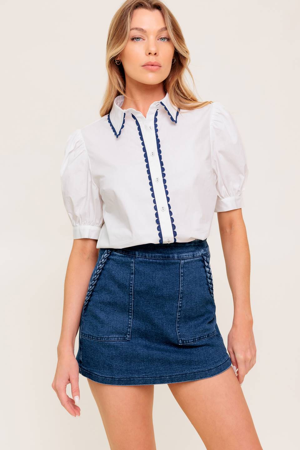 A solid woven top featuring collar, button down, short puff sleeve and laced edge.