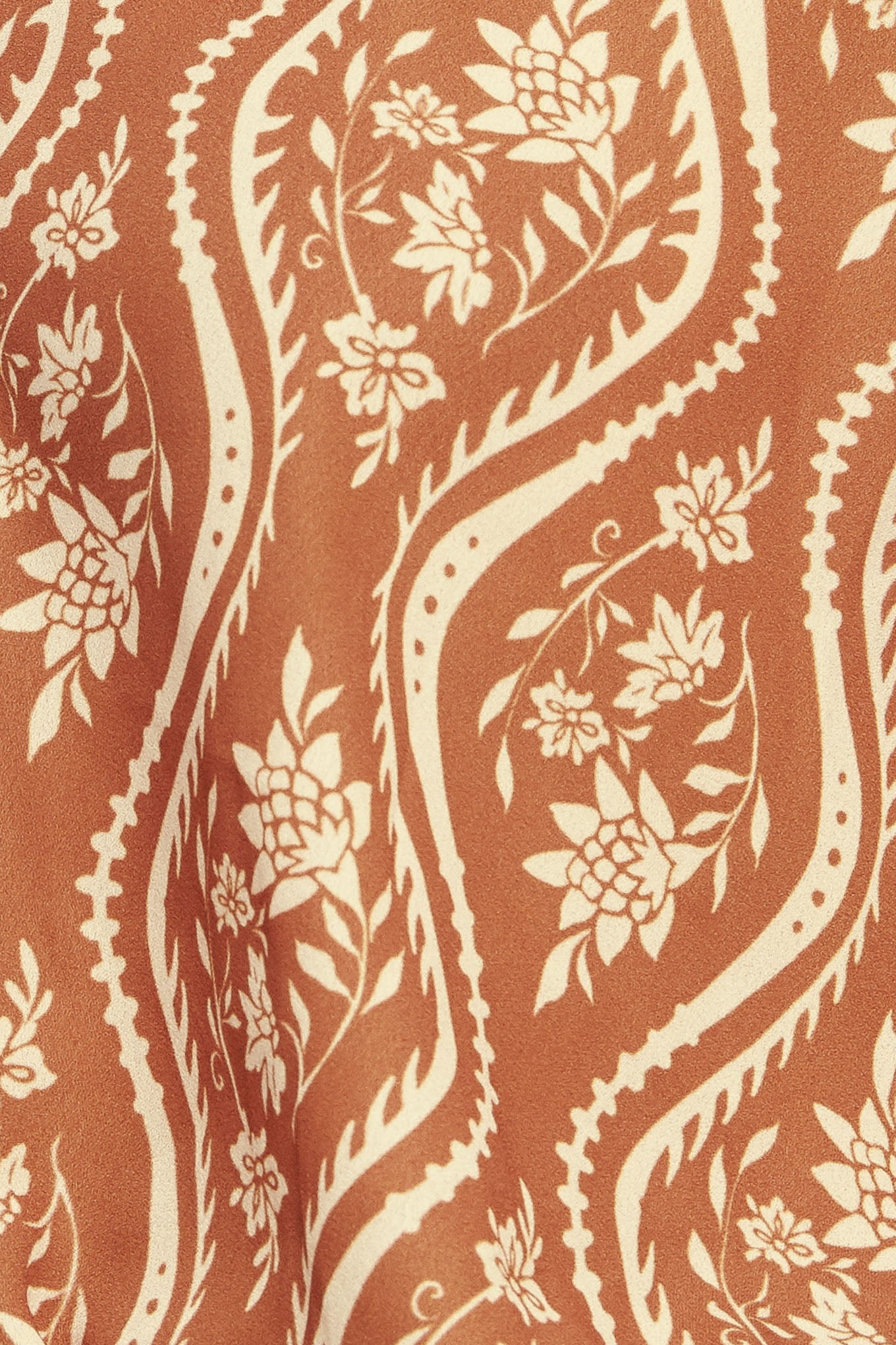 A printed woven top featuring round neckline with V front and long raglan sleeve