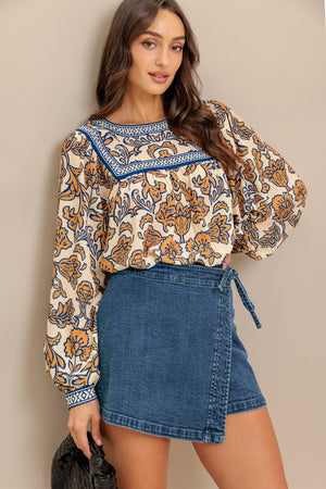 A printed woven top featuring round neckline, yoke, long sleeve and back neck button closure