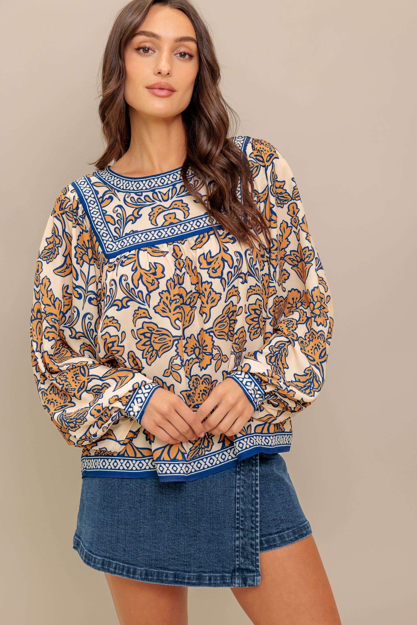 A printed woven top featuring round neckline, yoke, long sleeve and back neck button closure