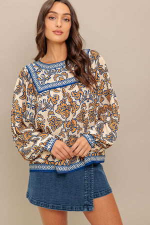 A printed woven top featuring round neckline, yoke, long sleeve and back neck button closure