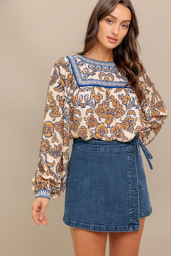 A printed woven top featuring round neckline, yoke, long sleeve and back neck button closure
