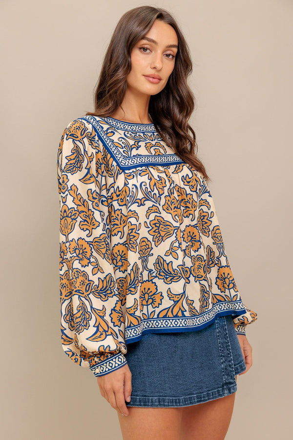 A printed woven top featuring round neckline, yoke, long sleeve and back neck button closure