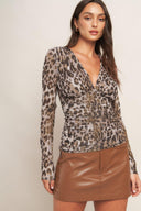 A printed power mesh top featuring V neckline, long sleeve and shirred side body