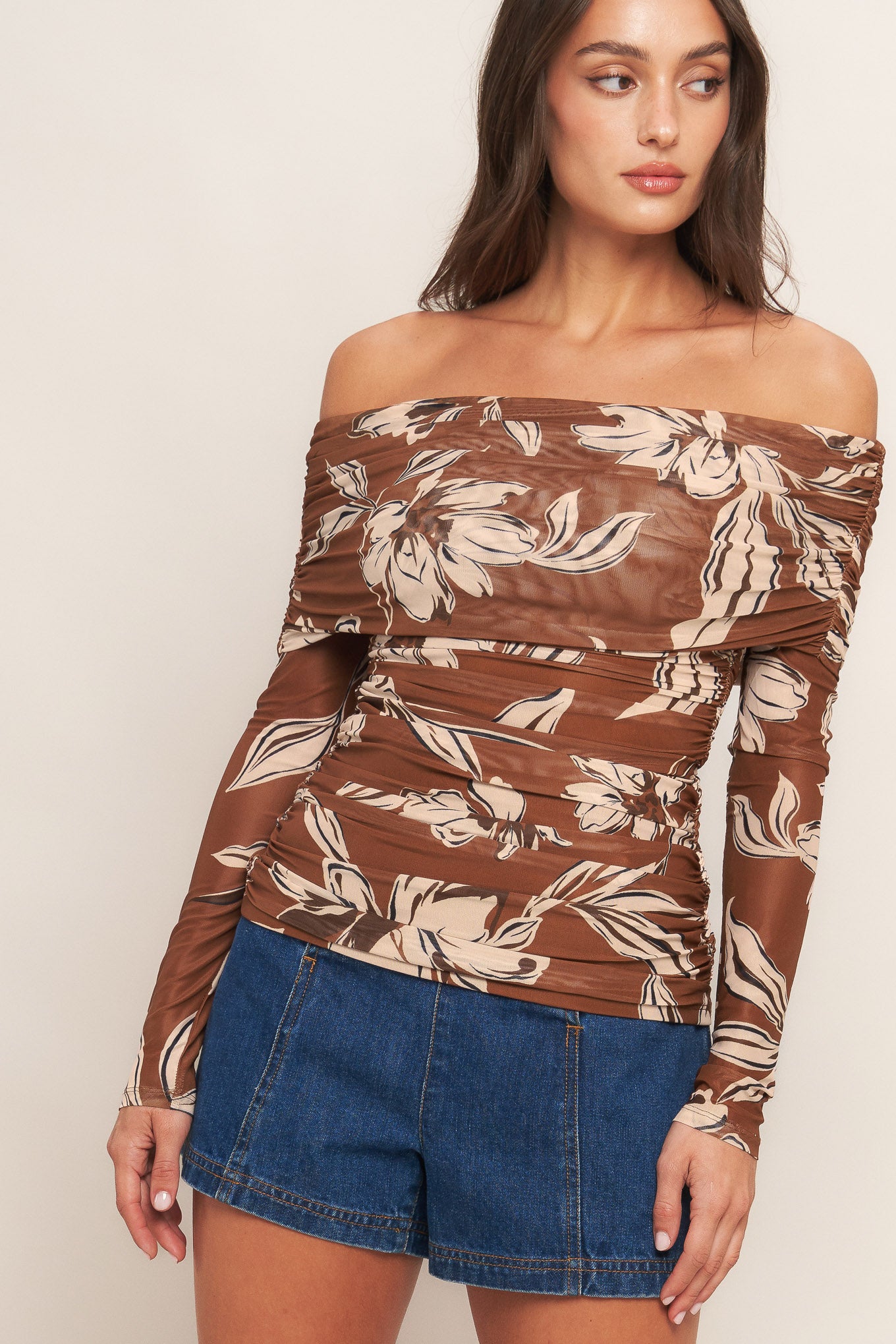 A printed power mesh top featuring off shoulder neckline, long sleeve and side shirring