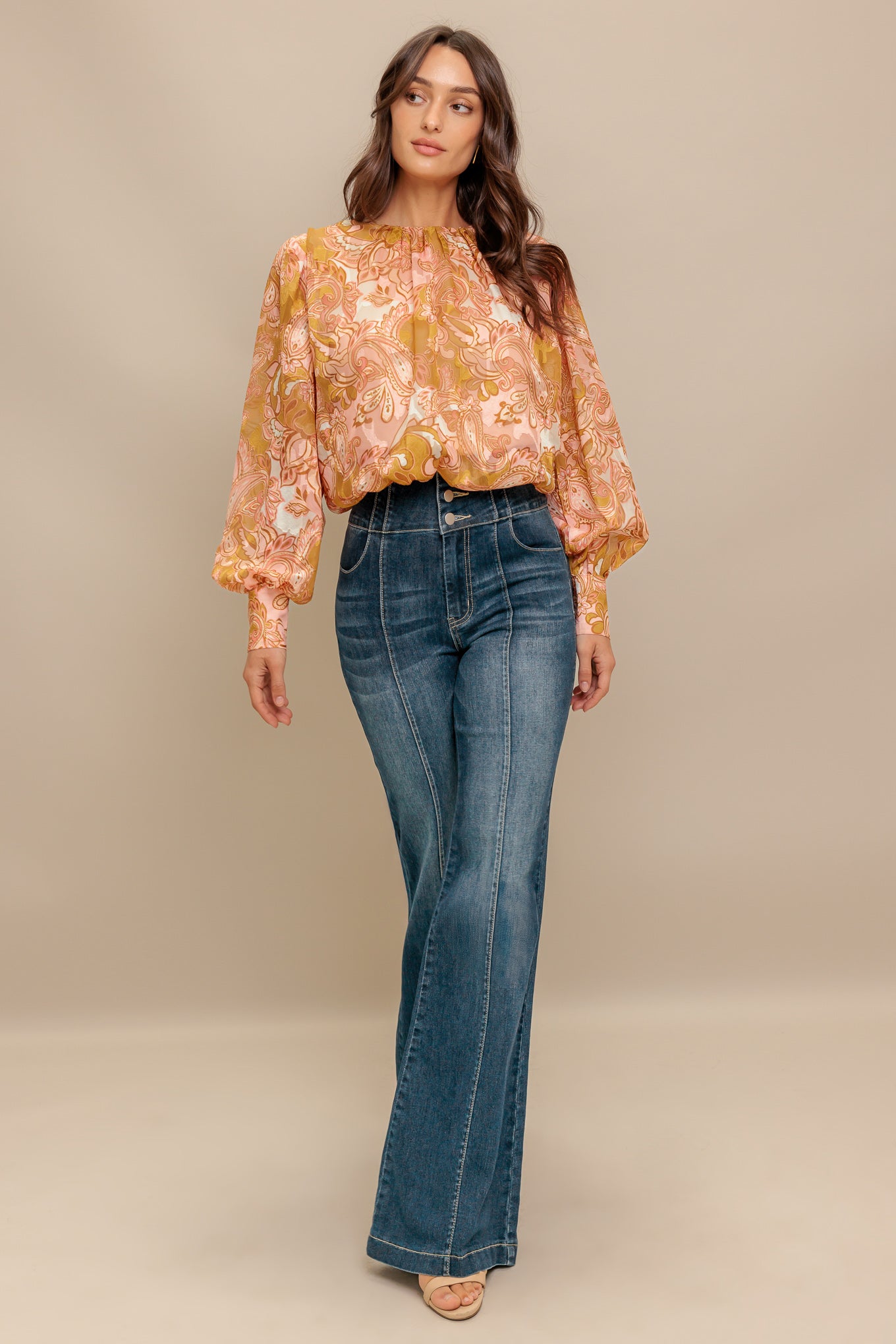 A printed woven jacquard top featuring round neckline, long blouson sleeve with cuff and back neck button closure
