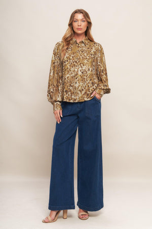 A printed woven top featuring collar, front button down and long blouson sleeve with cuff