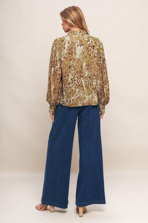 A printed woven top featuring collar, front button down and long blouson sleeve with cuff