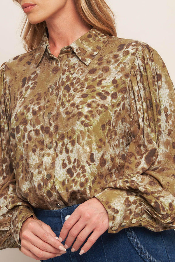 A printed woven top featuring collar, front button down and long blouson sleeve with cuff