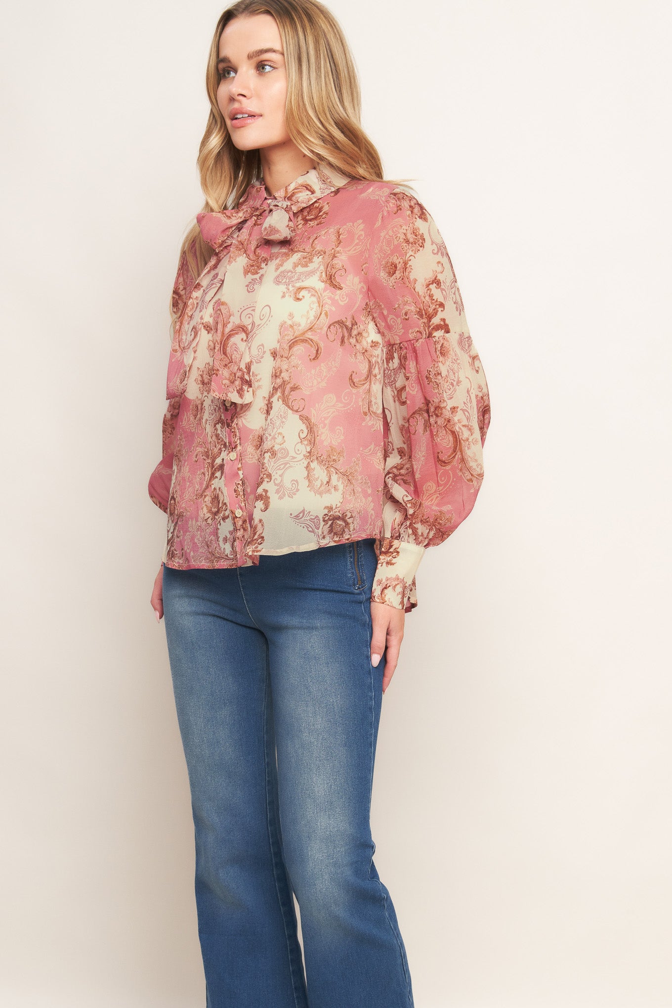 A printed woven top featuring collar, button down, neck tie and long lantern sleeve