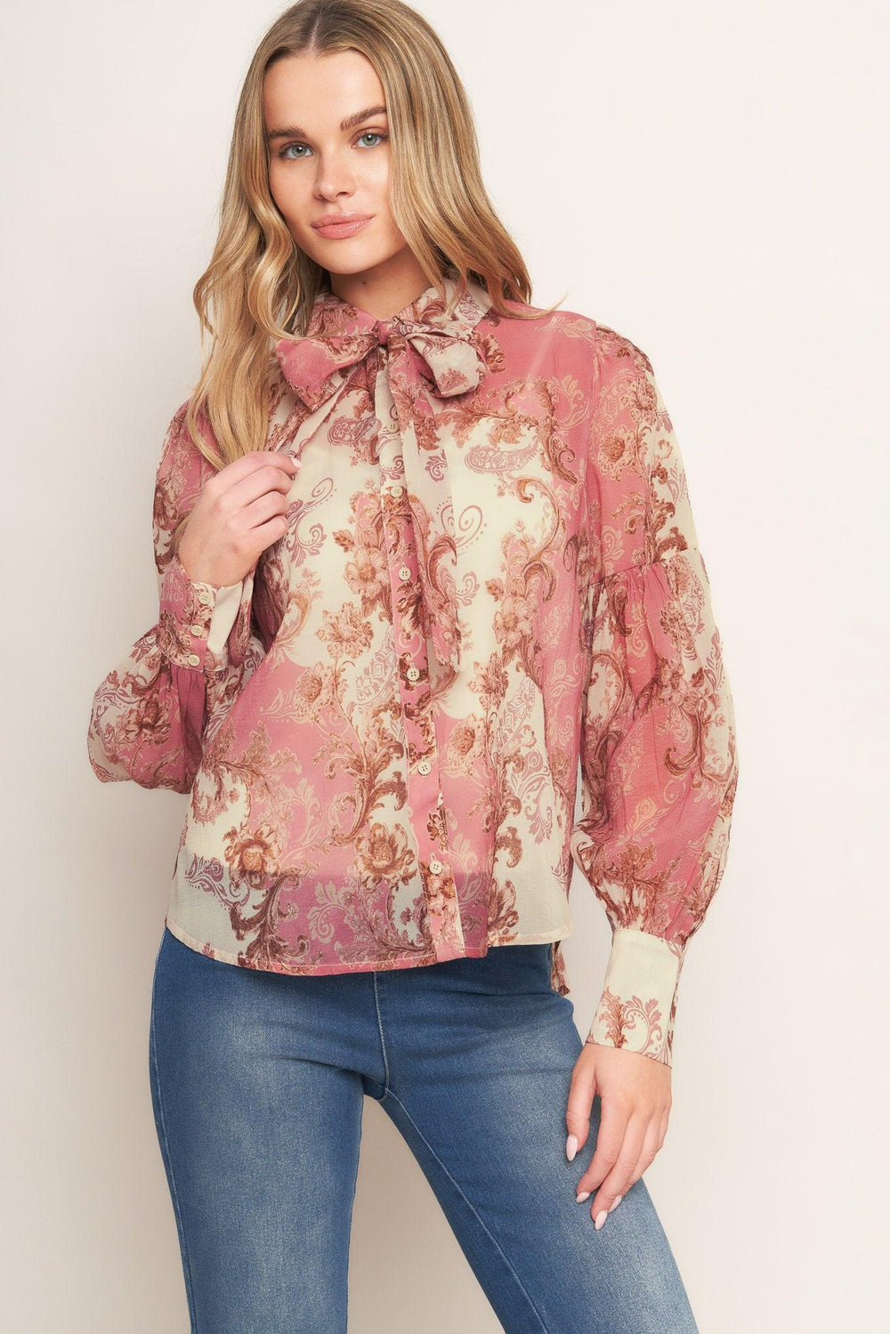 A printed woven top featuring collar, button down, neck tie and long lantern sleeve
