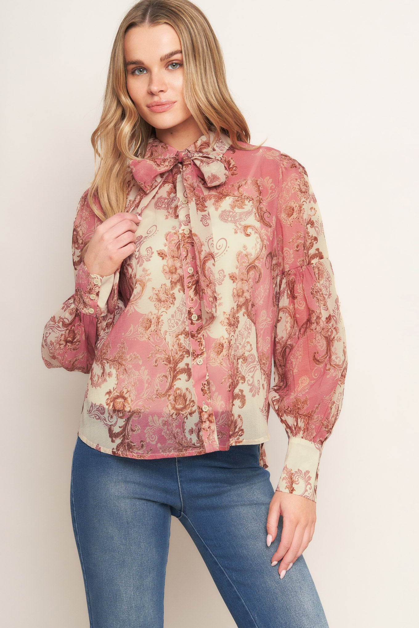 A printed woven top featuring collar, button down, neck tie and long lantern sleeve