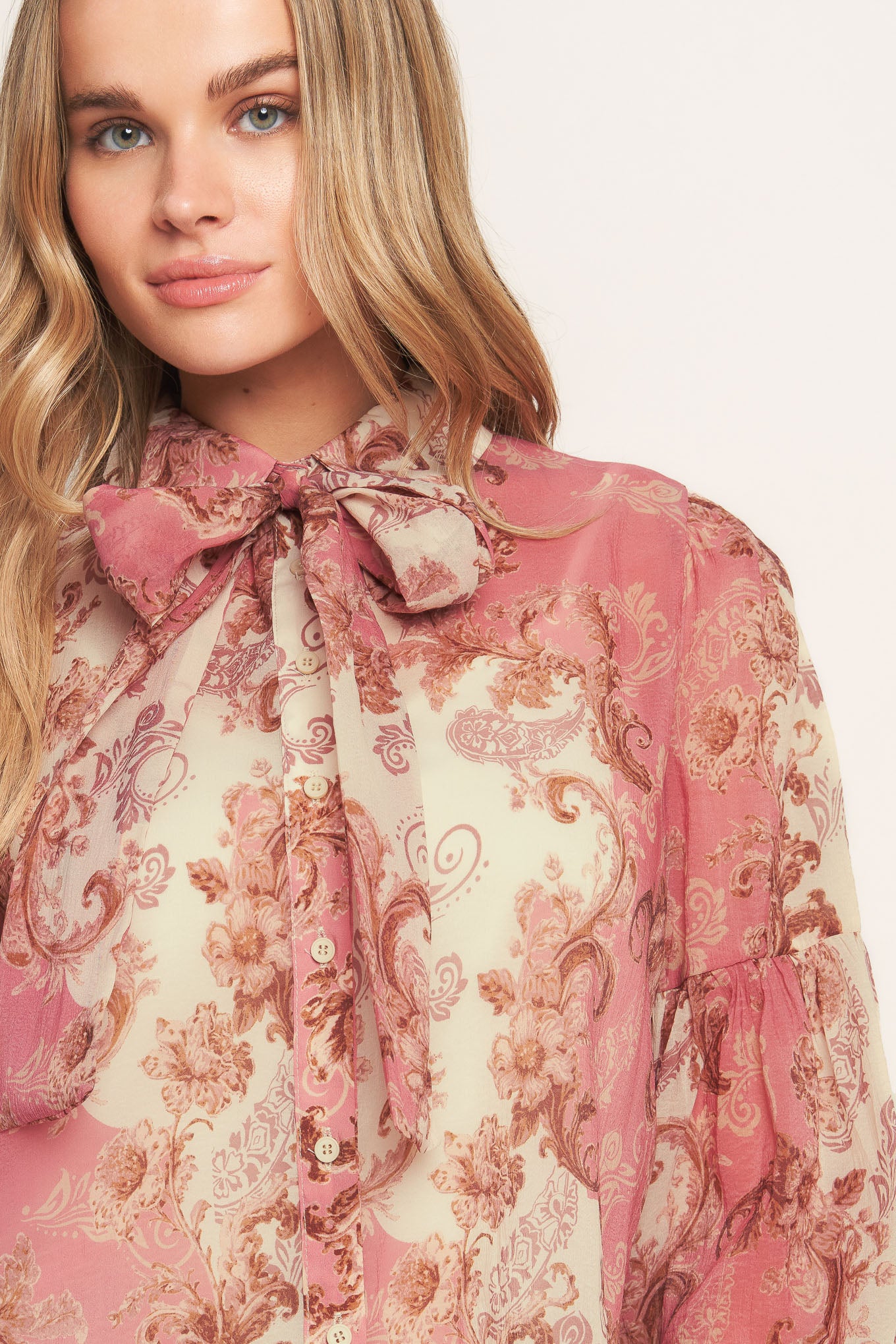 A printed woven top featuring collar, button down, neck tie and long lantern sleeve