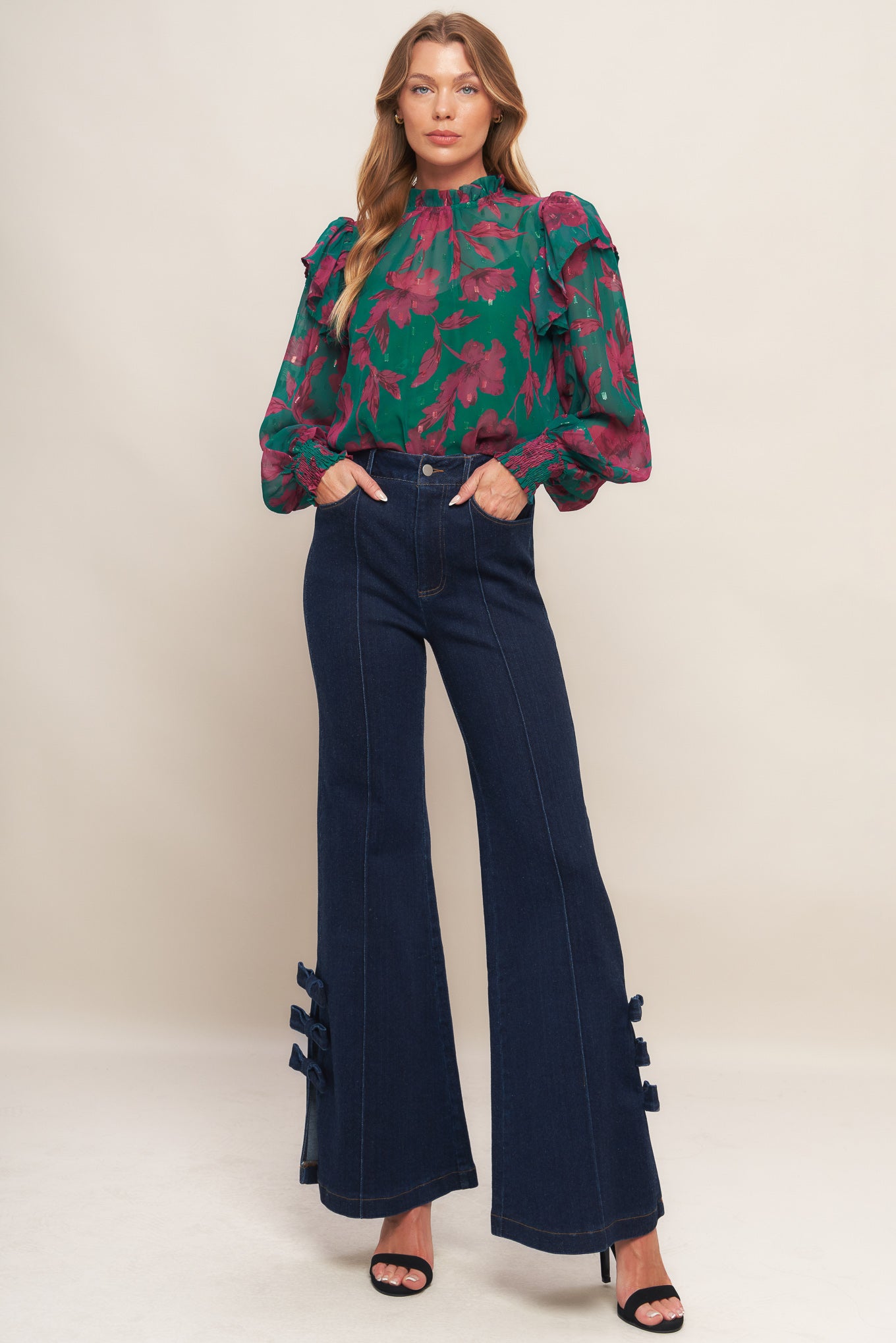 A printed woven top featuring high ruffled neckline, long sleeve with ruffed shoulder, back neck button closure and cami