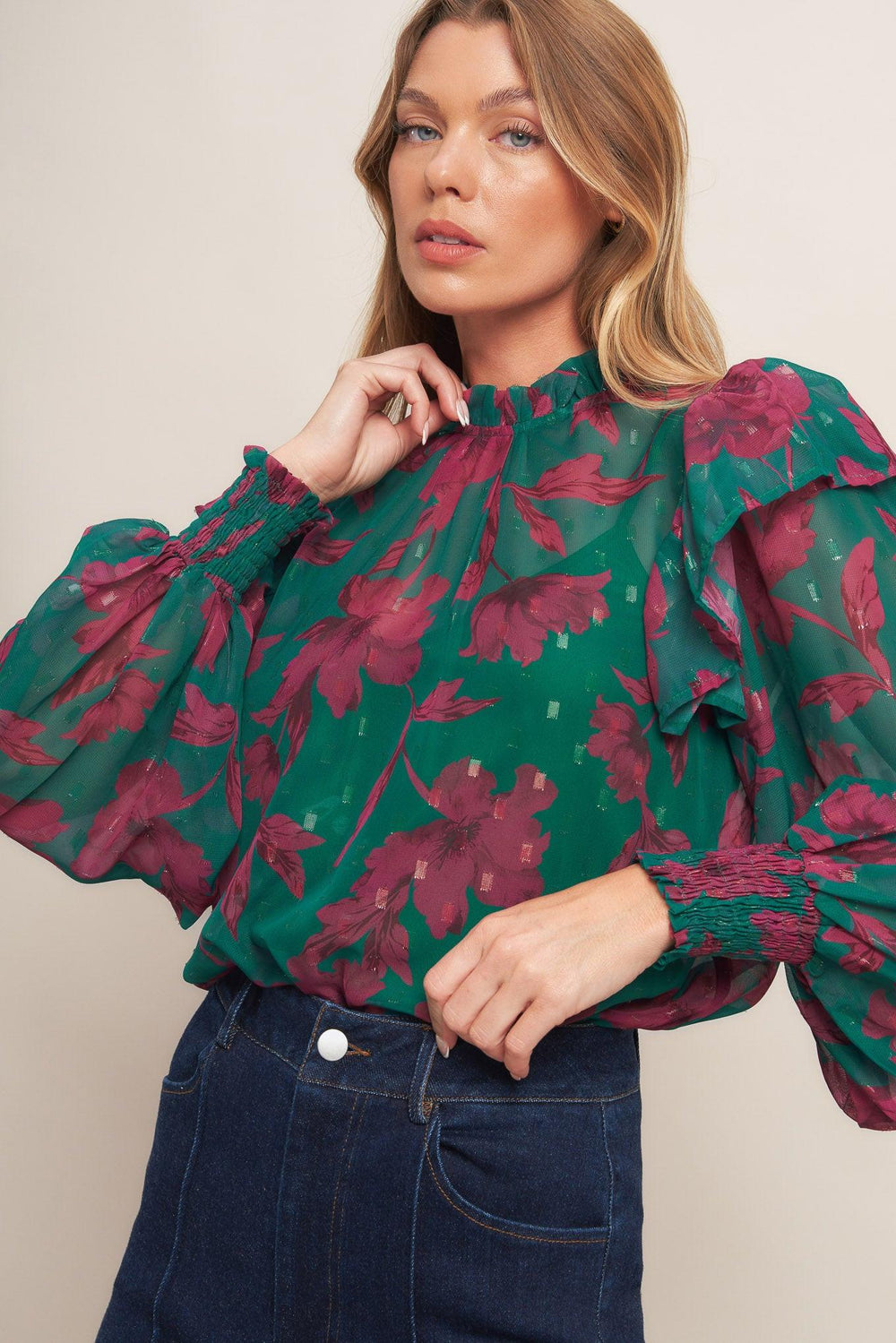 A printed woven top featuring high ruffled neckline, long sleeve with ruffed shoulder, back neck button closure and cami
