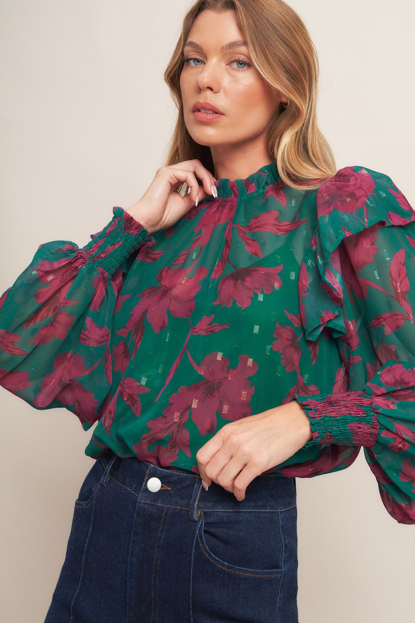 A printed woven top featuring high ruffled neckline, long sleeve with ruffed shoulder, back neck button closure and cami