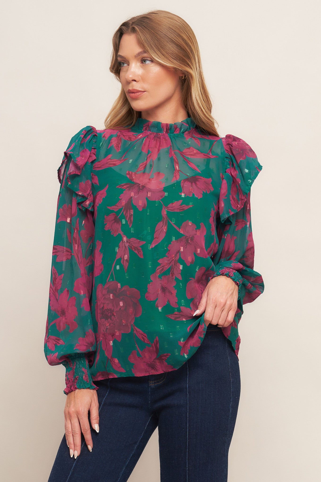 A printed woven top featuring high ruffled neckline, long sleeve with ruffed shoulder, back neck button closure and cami