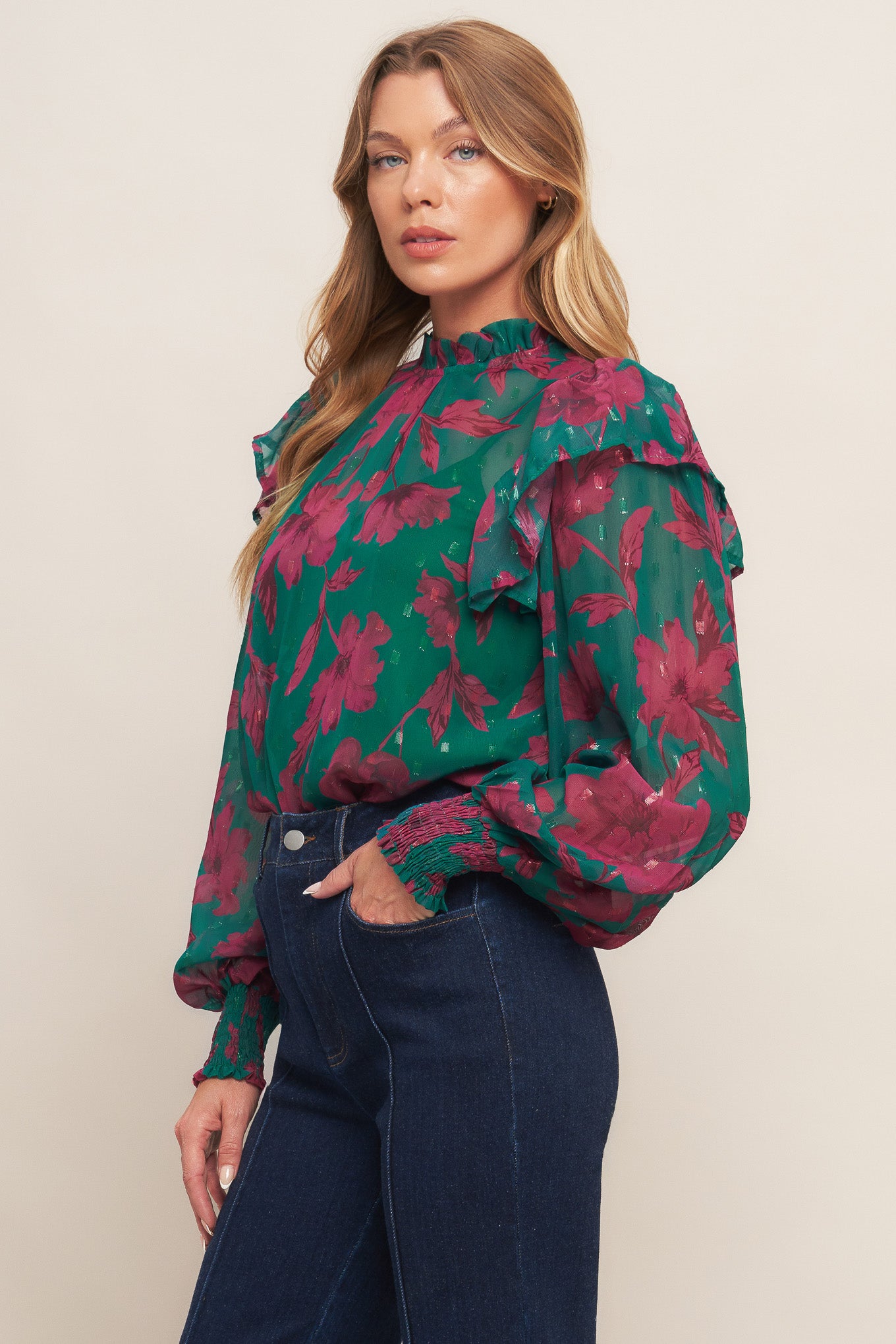 A printed woven top featuring high ruffled neckline, long sleeve with ruffed shoulder, back neck button closure and cami