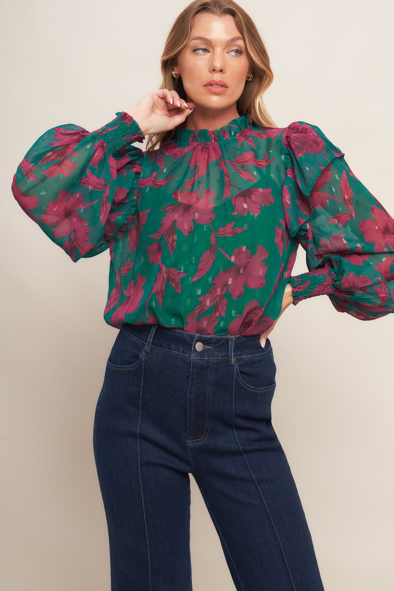 A printed woven top featuring high ruffled neckline, long sleeve with ruffed shoulder, back neck button closure and cami