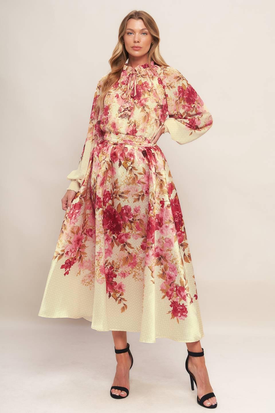 A printed woven top featuring ruffled neckline with front tie and long sleeve with smocked cuff