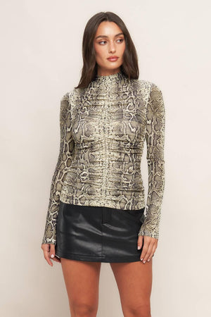 A printed knit top featuring high neckline, shirred front center and back neck button closure