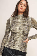 A printed knit top featuring high neckline, shirred front center and back neck button closure