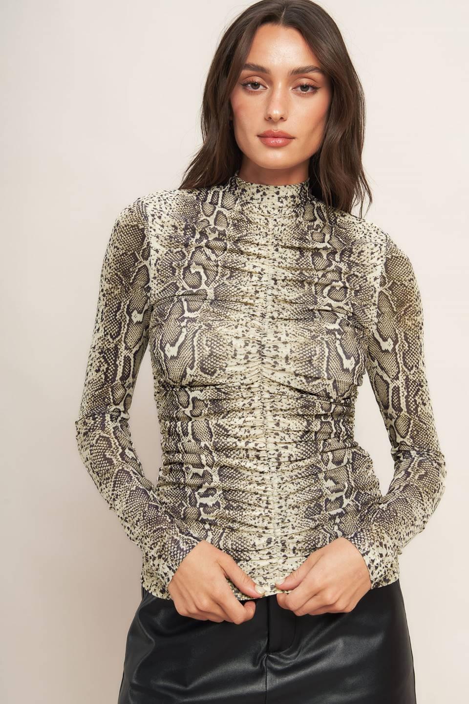 A printed knit top featuring high neckline, shirred front center and back neck button closure