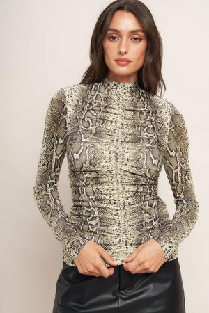 A printed knit top featuring high neckline, shirred front center and back neck button closure