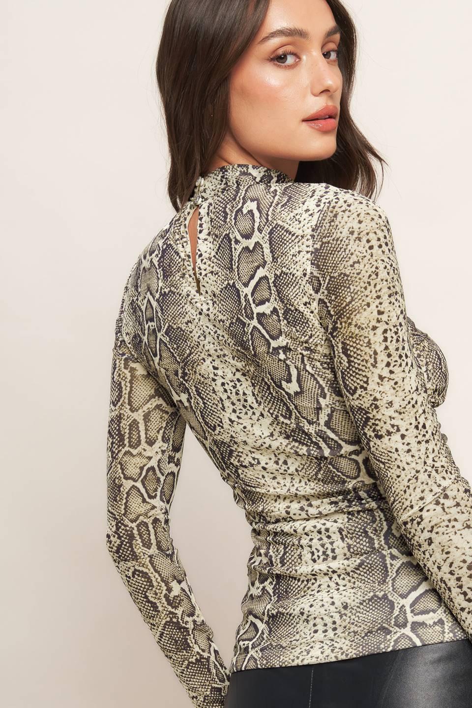 A printed knit top featuring high neckline, shirred front center and back neck button closure