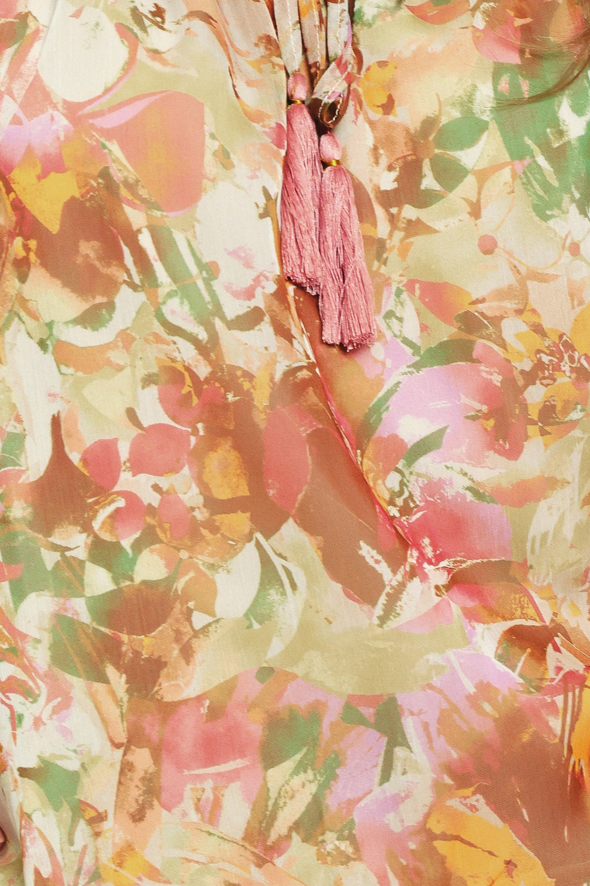 Woman wearing a long sleeve, u-neckline floral rust multicolor blouse with small bow detail and tassels on the center chest | Flying Tomato