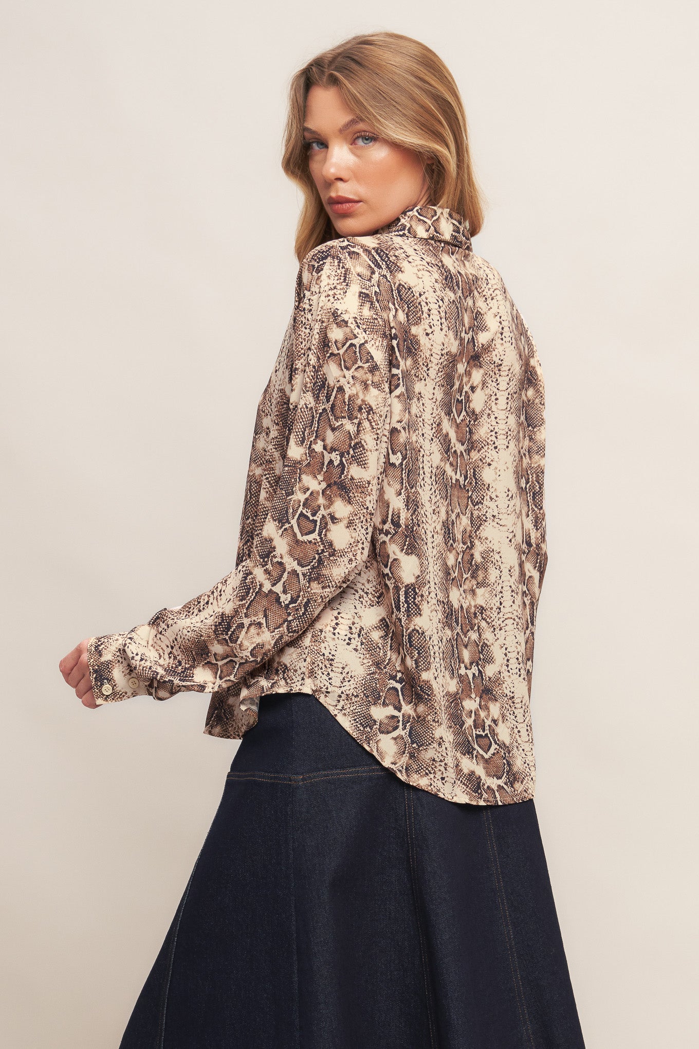 A printed woven top featuring collar, front button down and long sleeve with cuff