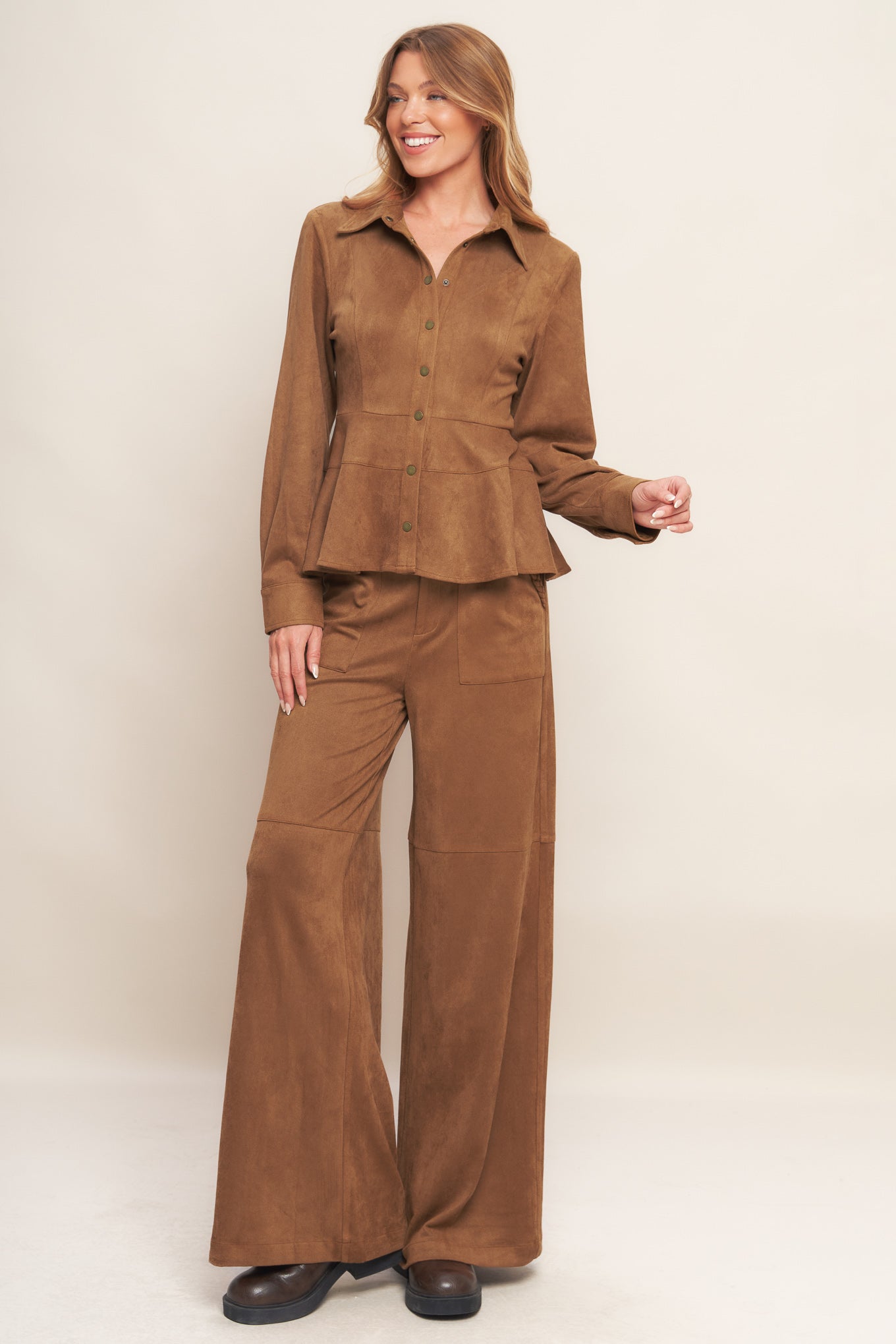 A faux suede top featuring collar, long sleeve, front button down and peplum.