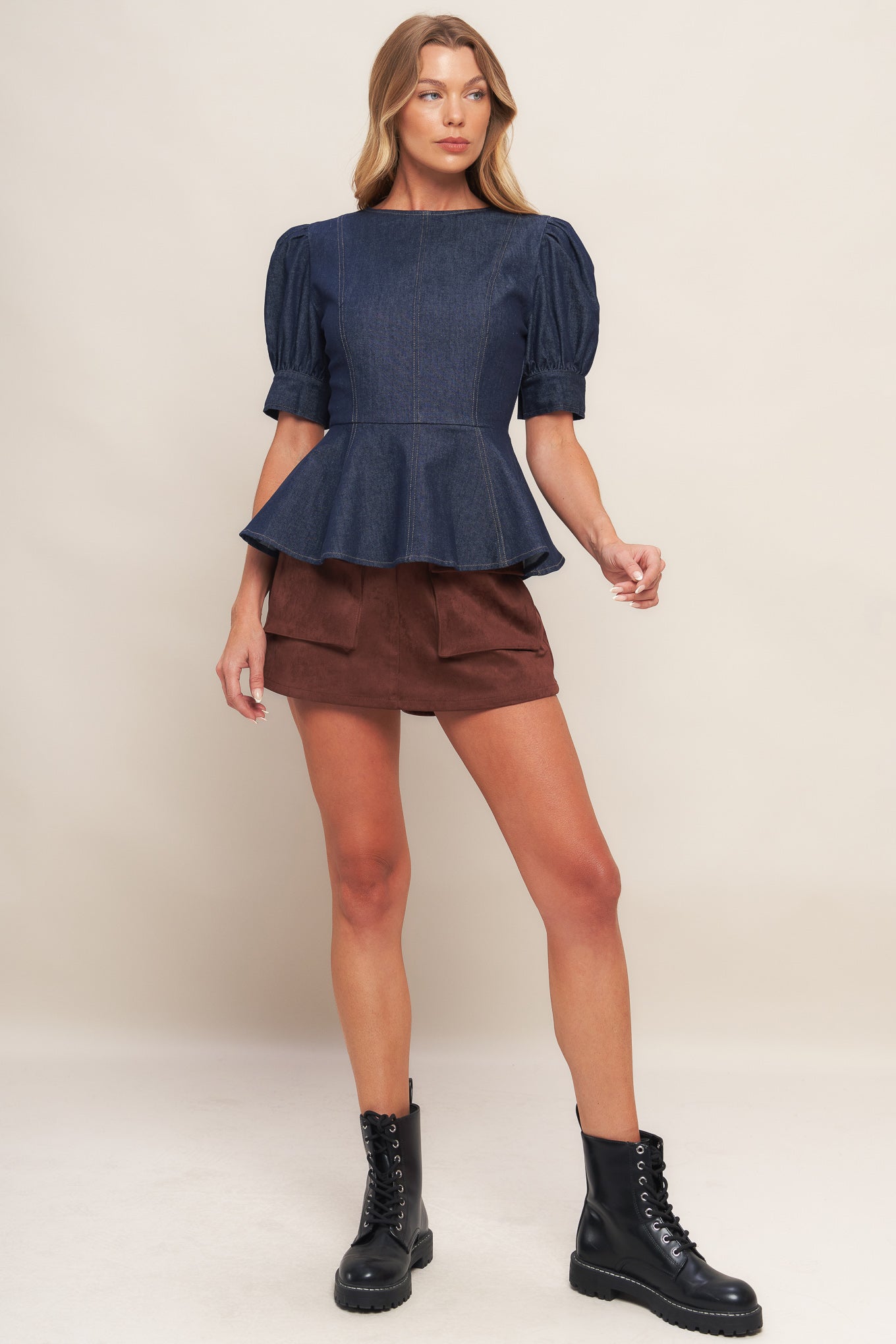 A denim top featuring round neckline, short puff sleeve with cuff, peplum and back zipper closure