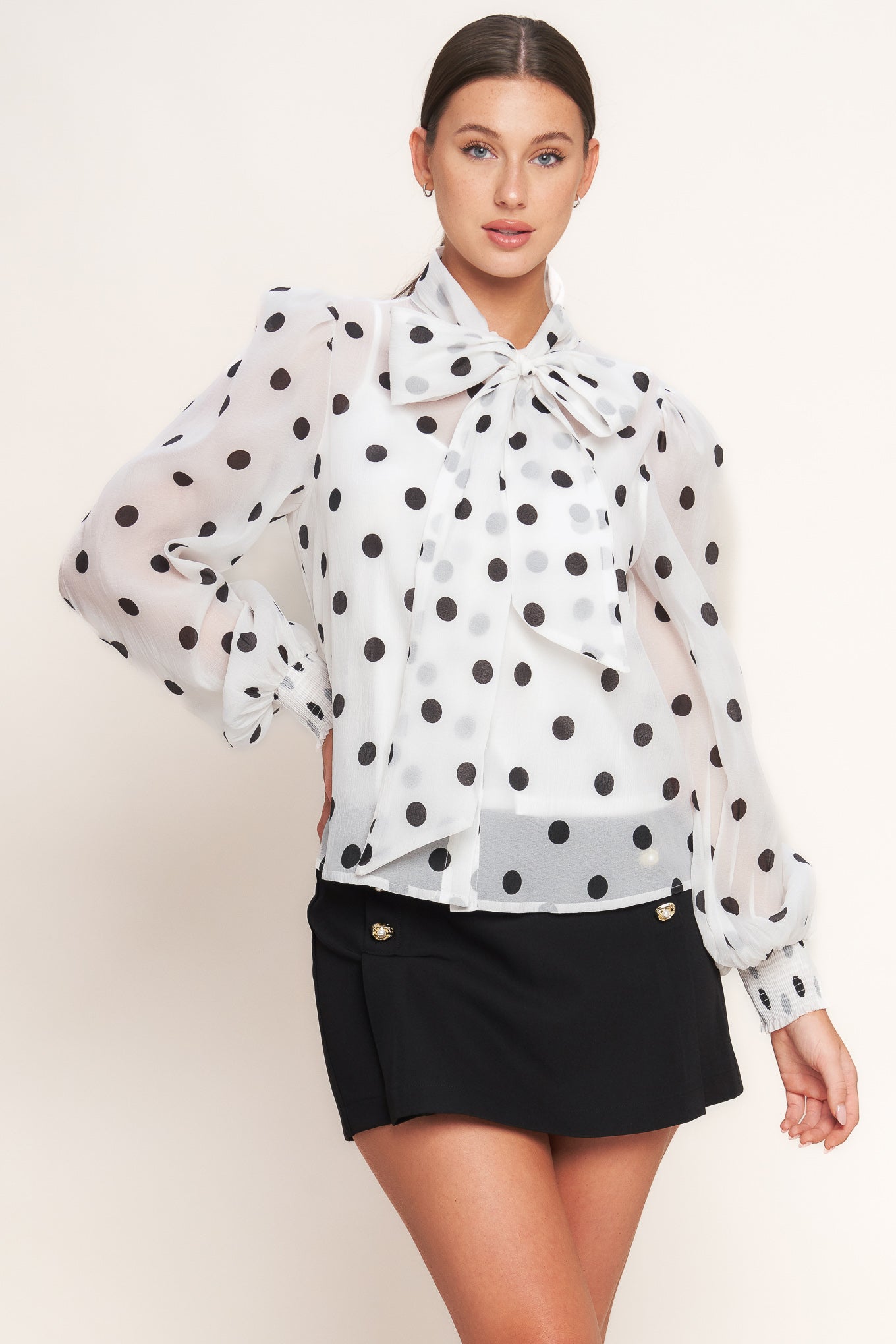 A printed woven top featuring front bow tie, long sleeve with smocked cuff, button down and cami