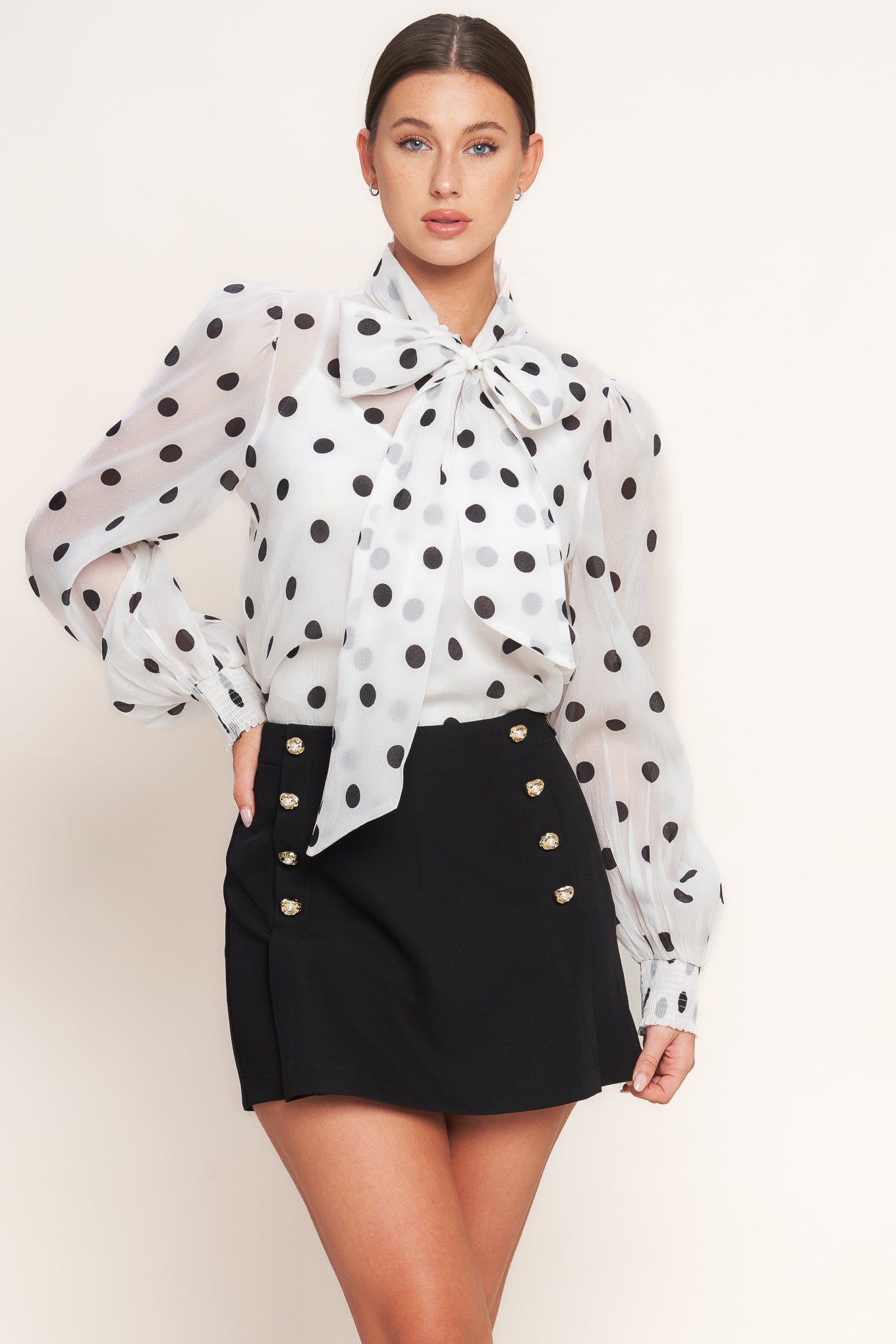 A printed woven top featuring front bow tie, long sleeve with smocked cuff, button down and cami