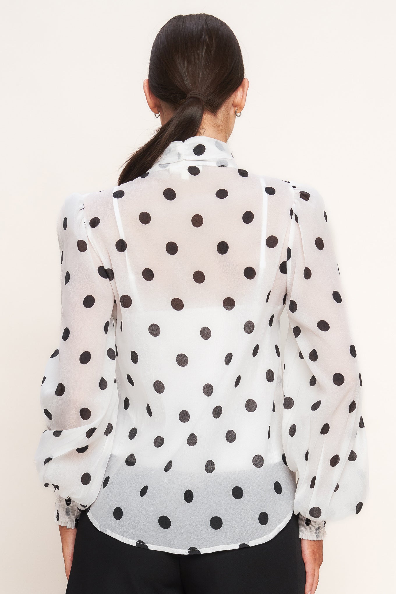 A printed woven top featuring front bow tie, long sleeve with smocked cuff, button down and cami