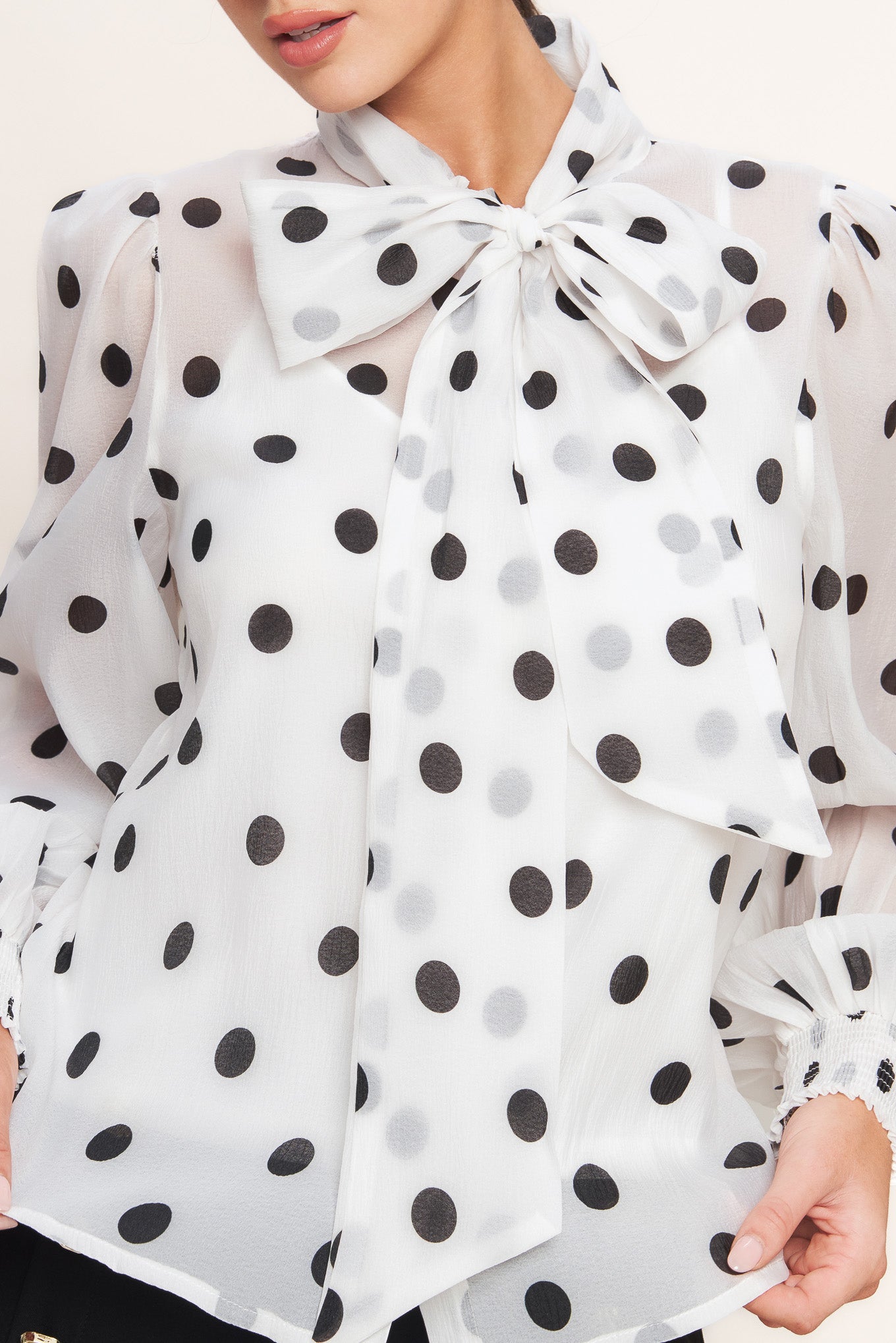 A printed woven top featuring front bow tie, long sleeve with smocked cuff, button down and cami