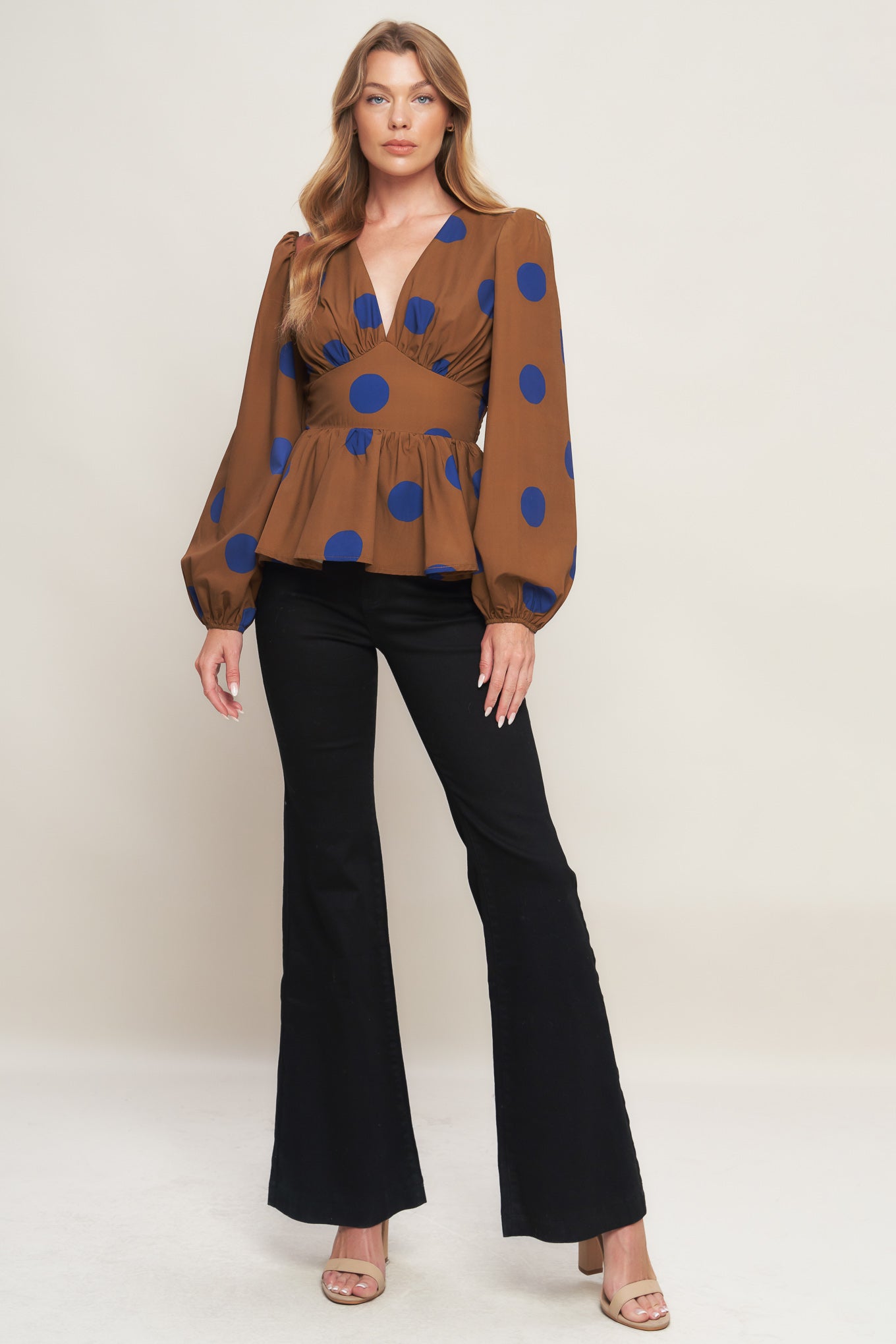 A printed woven top featuring V neckline, long sleeve, waist yoke, peplum and smocked back waist band