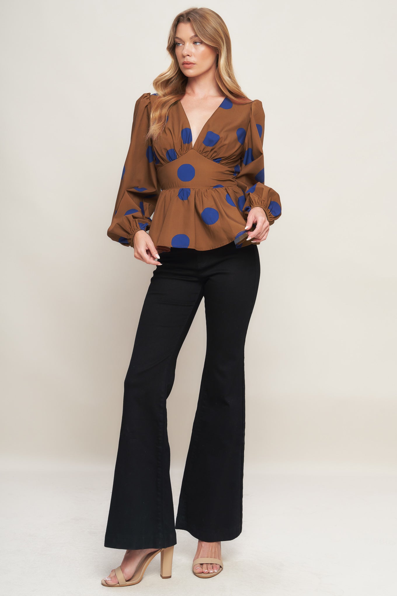 A printed woven top featuring V neckline, long sleeve, waist yoke, peplum and smocked back waist band