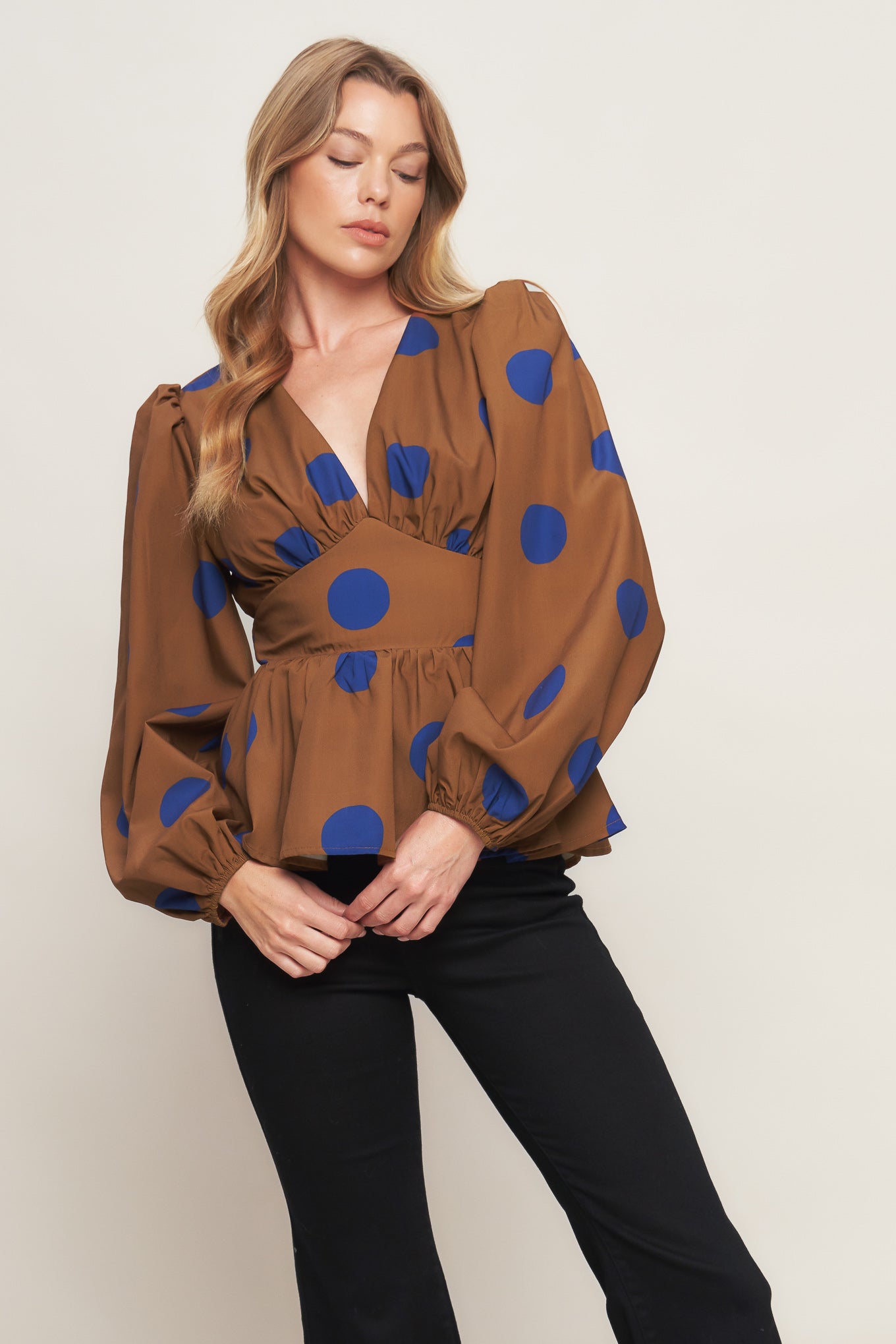 A printed woven top featuring V neckline, long sleeve, waist yoke, peplum and smocked back waist band