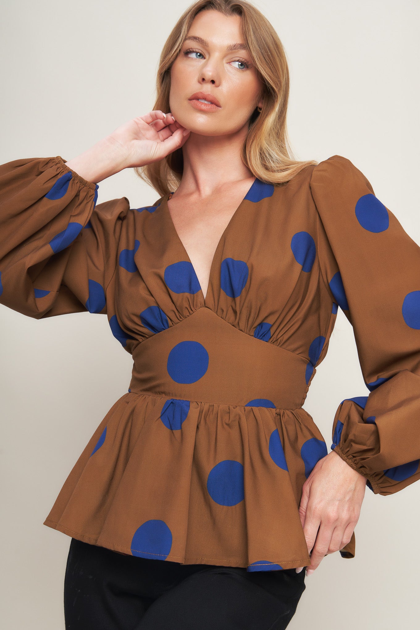 A printed woven top featuring V neckline, long sleeve, waist yoke, peplum and smocked back waist band