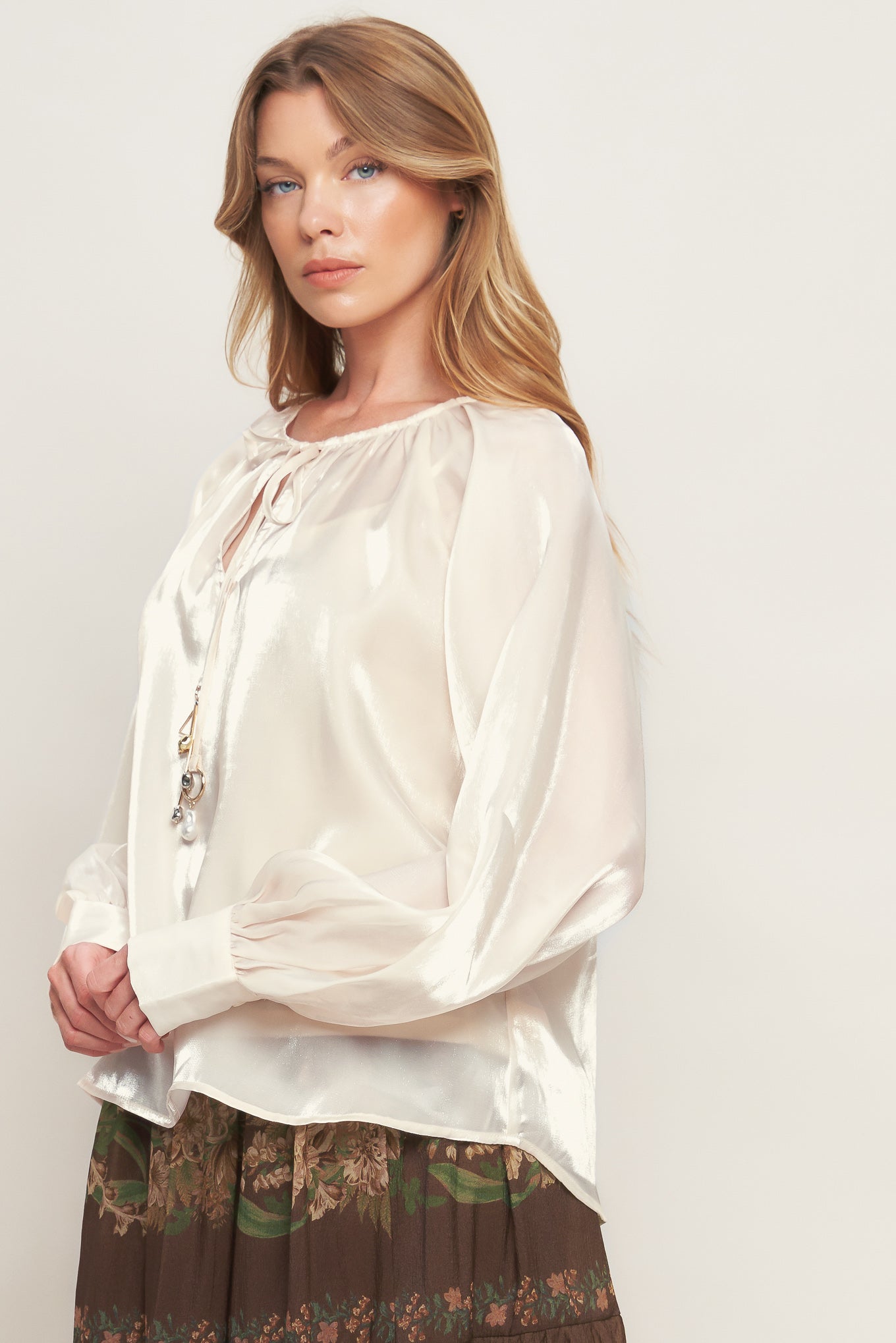 A solid sheen woven peasant top with front tie with embellishment, long sleeve with cuff and cami