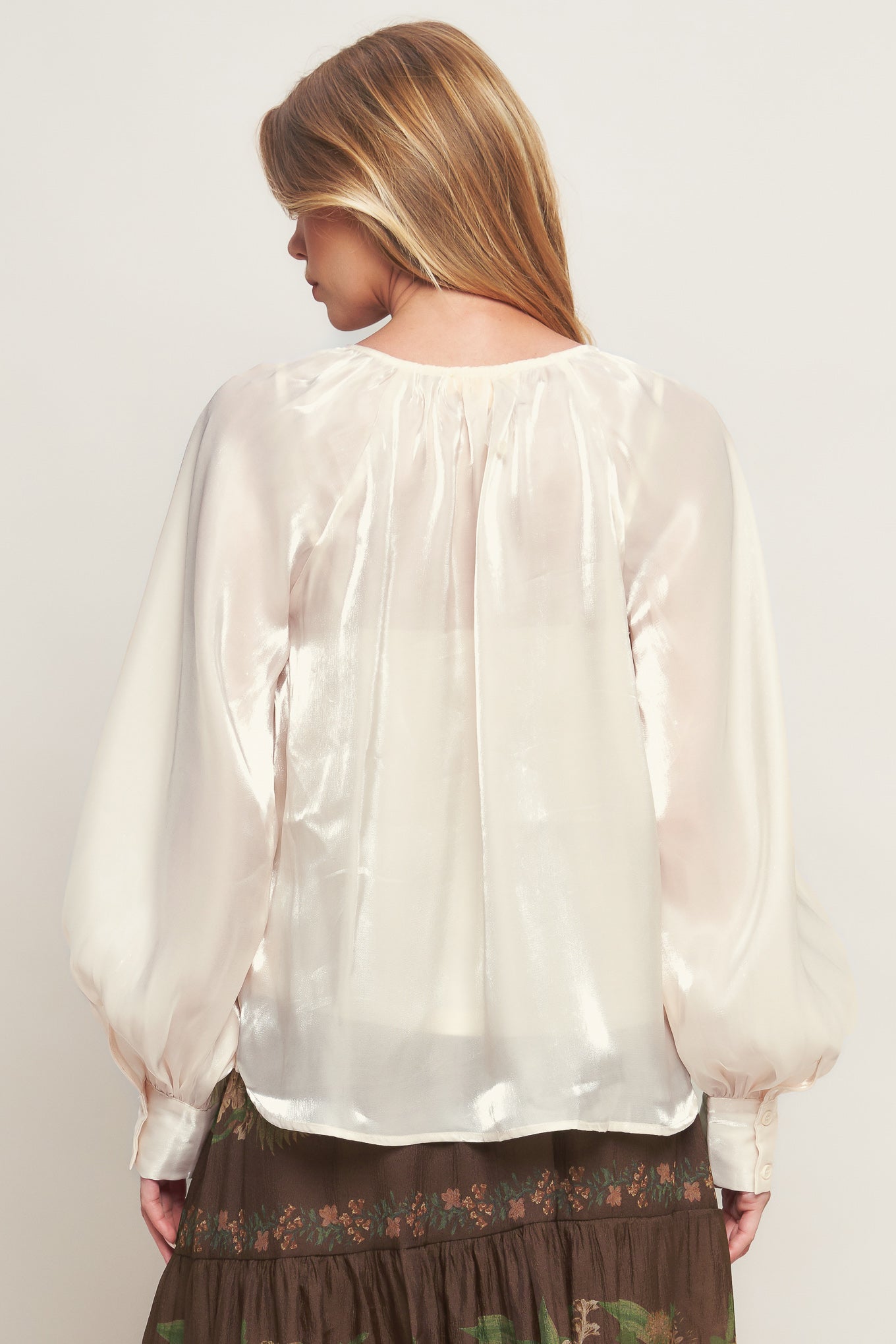 A solid sheen woven peasant top with front tie with embellishment, long sleeve with cuff and cami