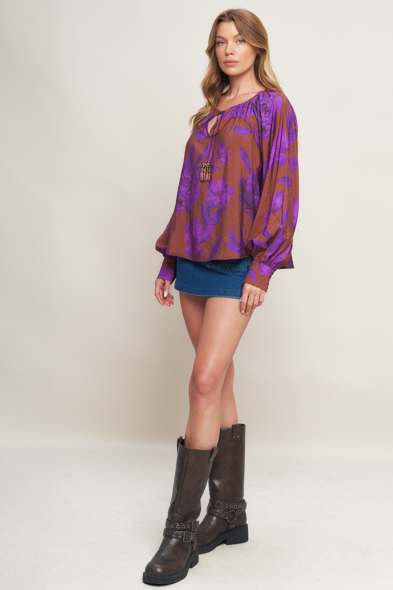 A printed woven peasant top featuring round neckline with tie and long sleeve with cuff