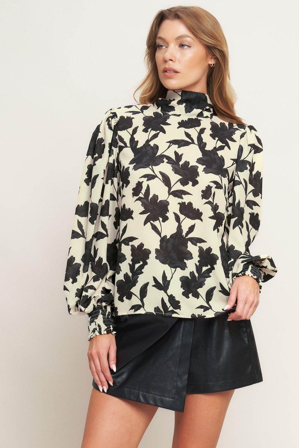 A printed woven top featuring high neckline, long sleeve and back bow tie closure