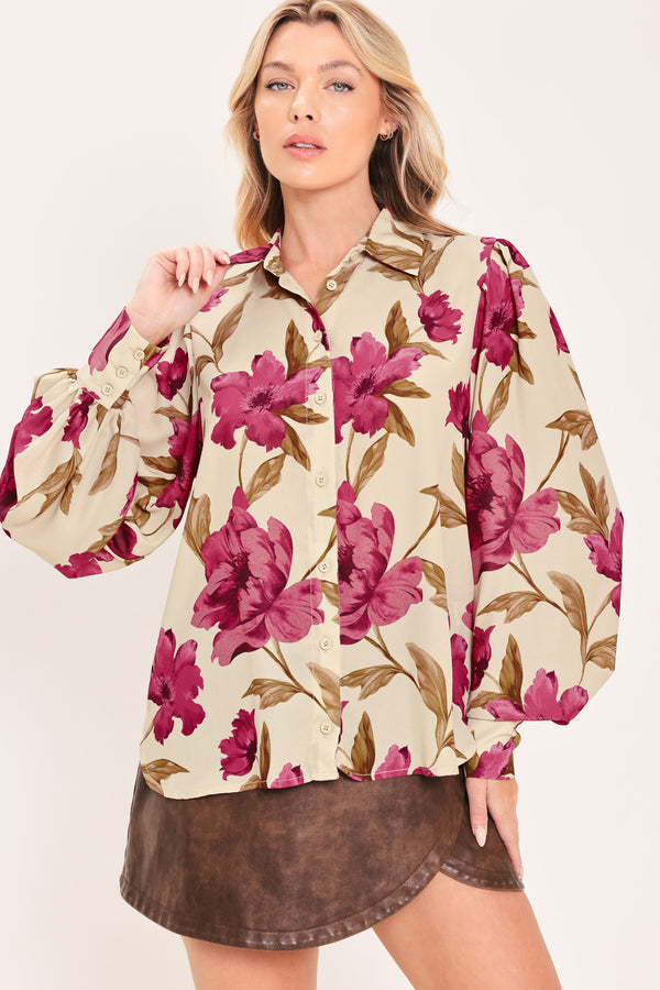 A woman modeling a cream-colored long-sleeve button-up blouse with a bold magenta and brown floral print | Flying Tomato