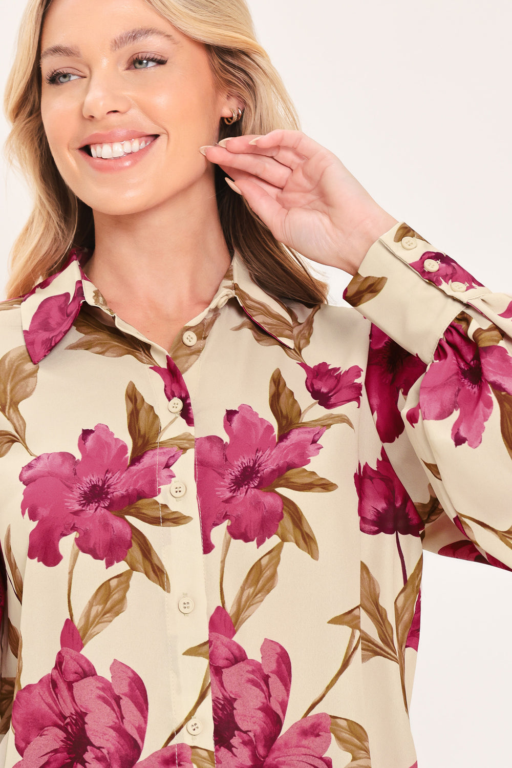 A woman modeling a cream-colored long-sleeve button-up blouse with a bold magenta and brown floral print | Flying Tomato
