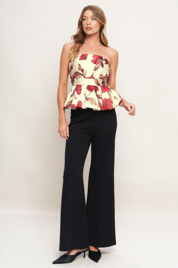 A printed woven top featuring strapless neckline, pleated body, peplum and smocked back bodice. 